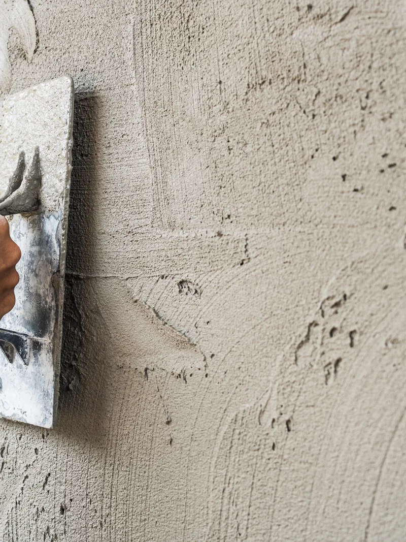 Troweling a fresh finish coat over existing stucco